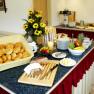Breakfast buffet with bread rolls, fruit and flowers.
