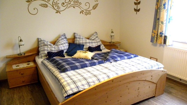Cozy bedroom with wooden bed and blue bed linen.