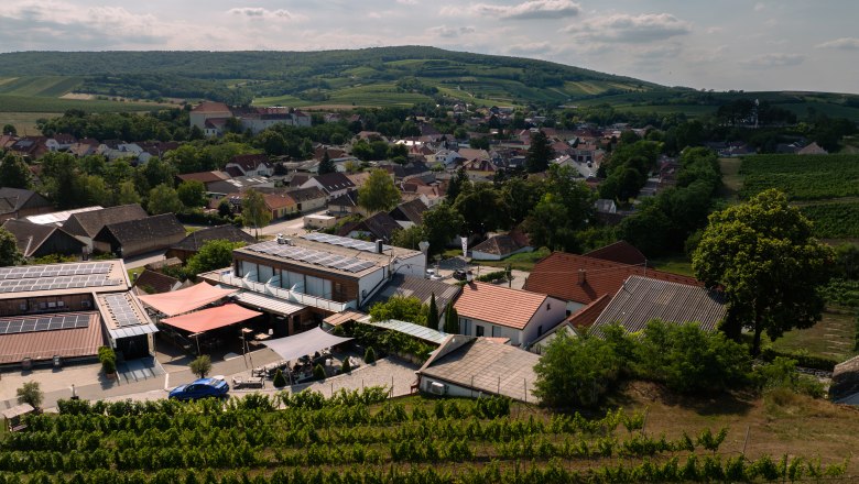 Aerial view of a winery with surrounding buildings and vineyards.