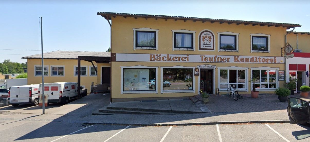 Exterior view of the Teufner bakery with yellow facade and shop windows.