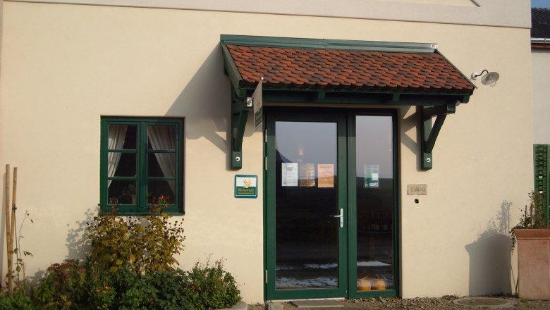 Entrance to a farm store with green door frame and small canopy.