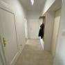 Hallway of the flat with light-coloured tiles and wardrobe