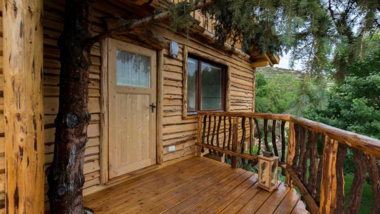 Terrace of a wooden tree house with entrance door