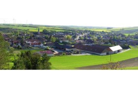 Landscape with village and church, surrounded by fields.