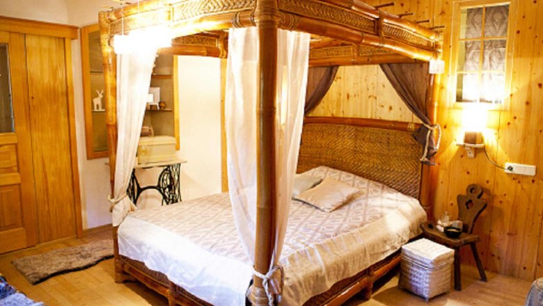 Cozy bedroom with wooden four-poster bed and rustic furnishings.