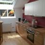 Modern kitchen with wooden worktop, skylight and murals.