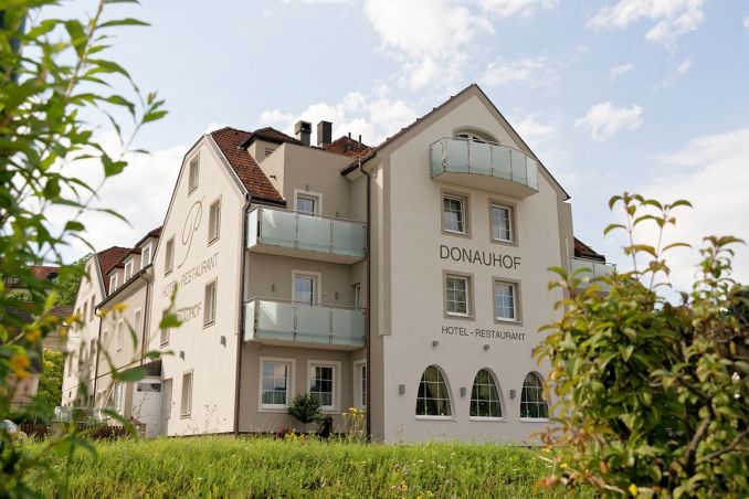 Exterior view of the Hotel Restaurant Donauhof with balconies and garden.