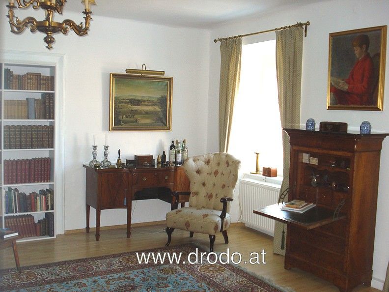 Classic living room with antique furniture, paintings and bookshelf.