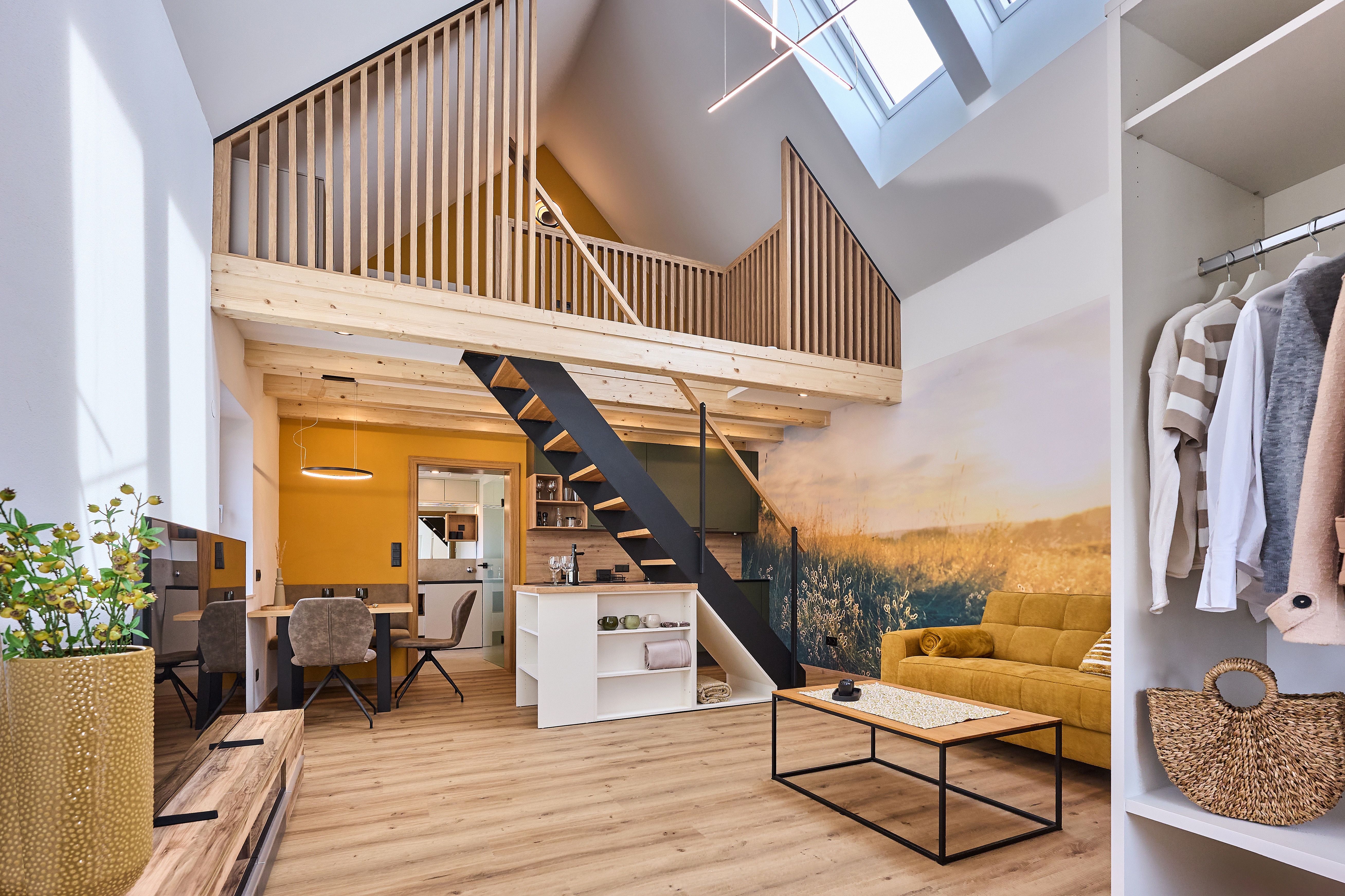 Modern loft with open gallery, yellow sofa and wooden elements.