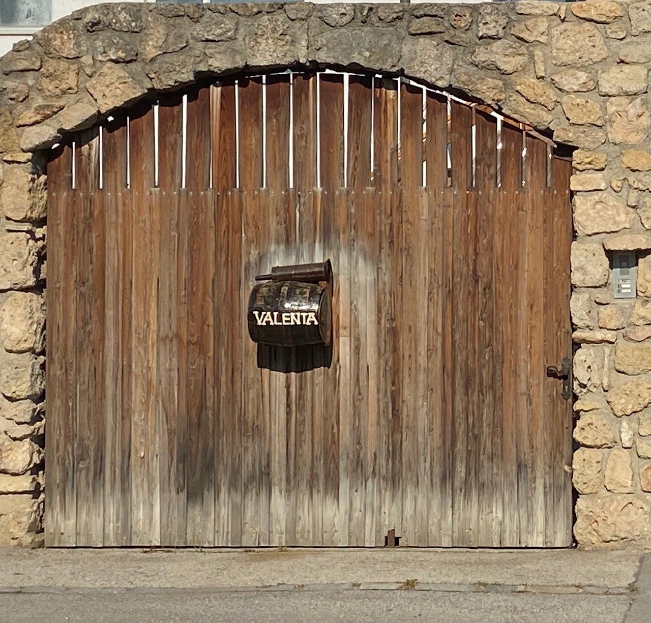 Wooden gate with letterbox and inscription 'Valenta'.