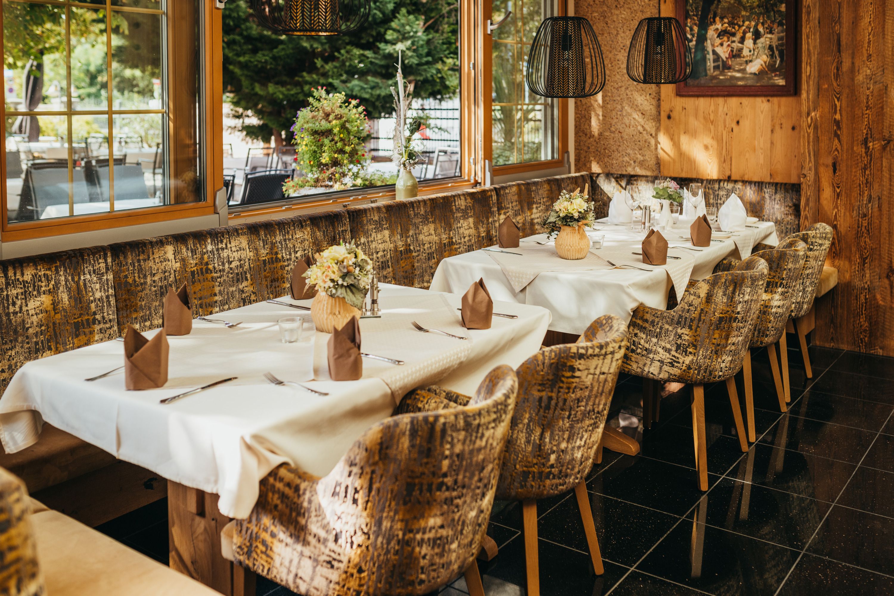 Cozy restaurant with laid tables, flowers and rustic ambience.