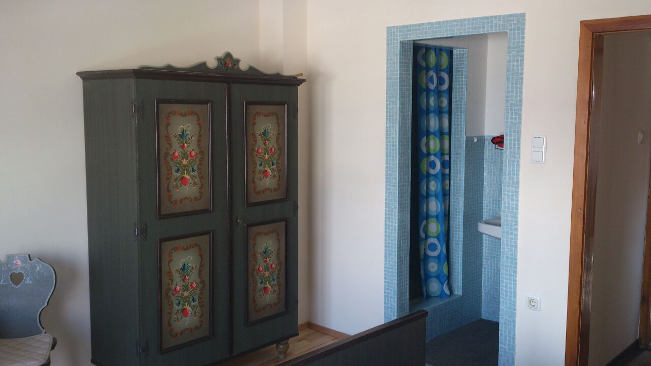 Interior with painted cupboard and blue tiled bathroom.