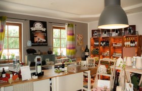 Interior view of a farm store with shelves full of wine bottles and products.
