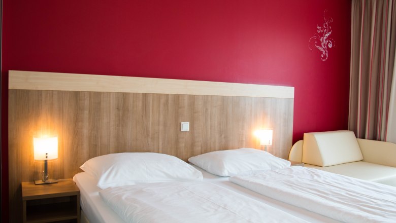 Bedroom with double bed and red wall