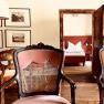 Cozy apartment with antique furniture and wooden floor, view into the bedroom with double bed.