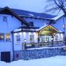 An inn covered in snow in winter, illuminated with lights and decorations.