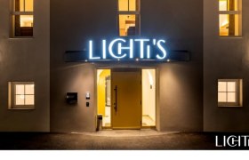 Entrance area of a building with illuminated sign 'LICHTI'S'.