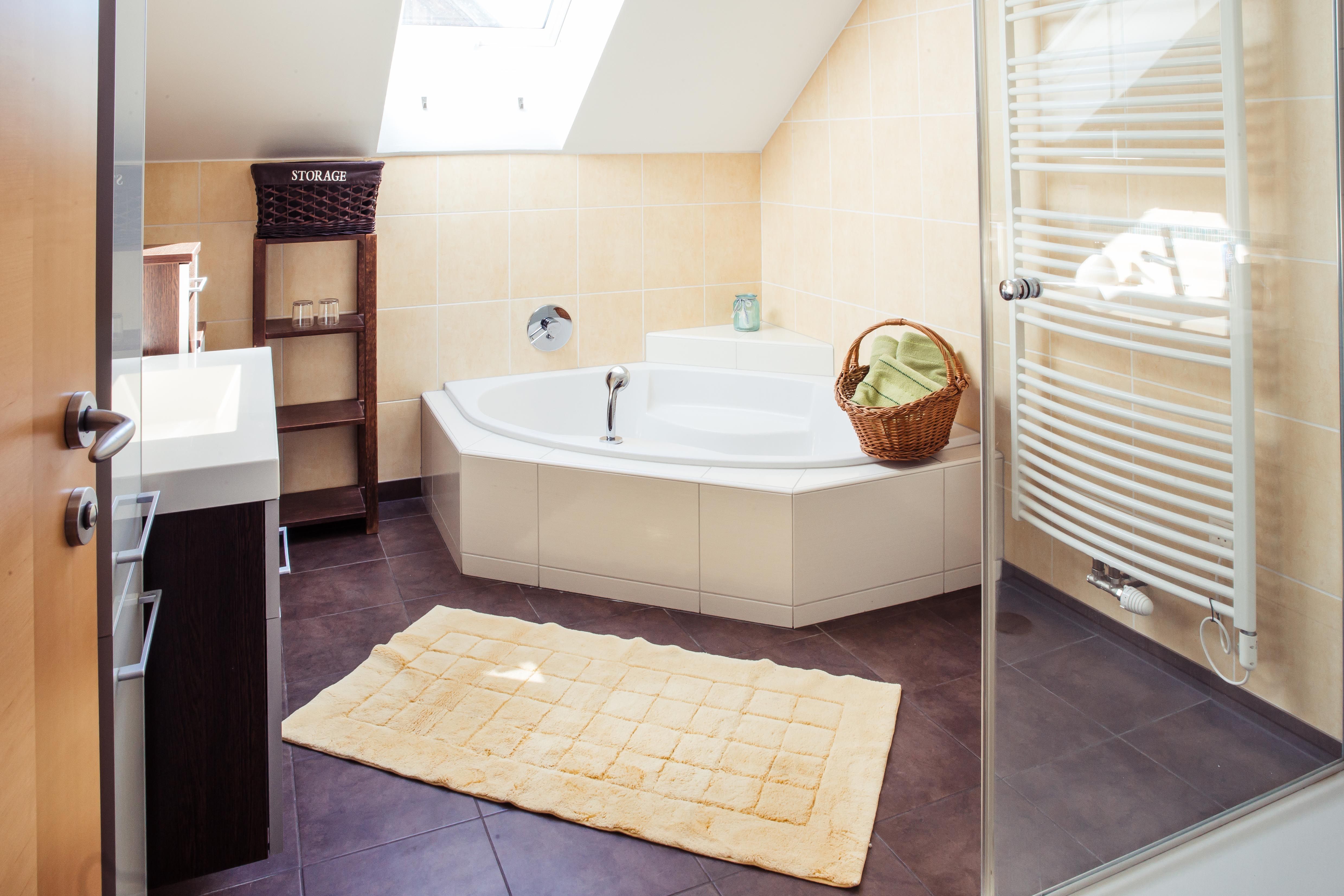 Modern bathroom with bathtub, towel rail and skylight.