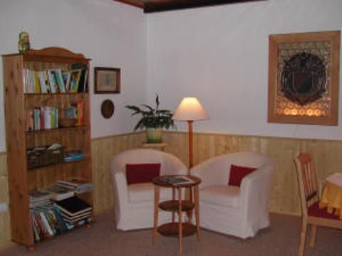 Cozy sitting area with two armchairs, a small table, bookshelf and floor lamp.