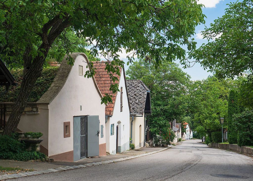A picturesque wine cellar lane with traditional houses and trees in Stixneusiedl, Lower Austria