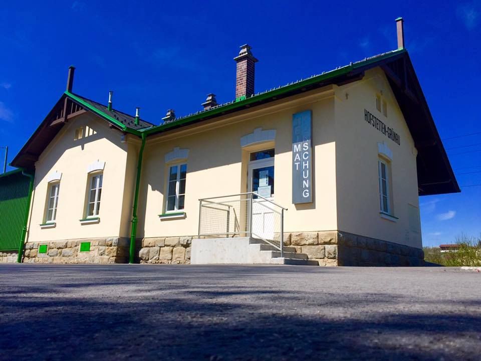 Exterior view of a small museum building with a yellow façade and green accents.