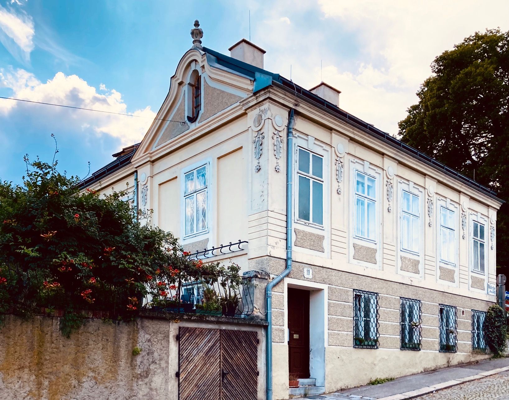 Exterior view of a historic villa with ornate windows and a gable.