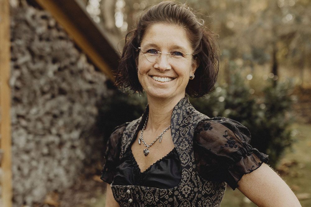 Woman in traditional dress smiling outdoors.