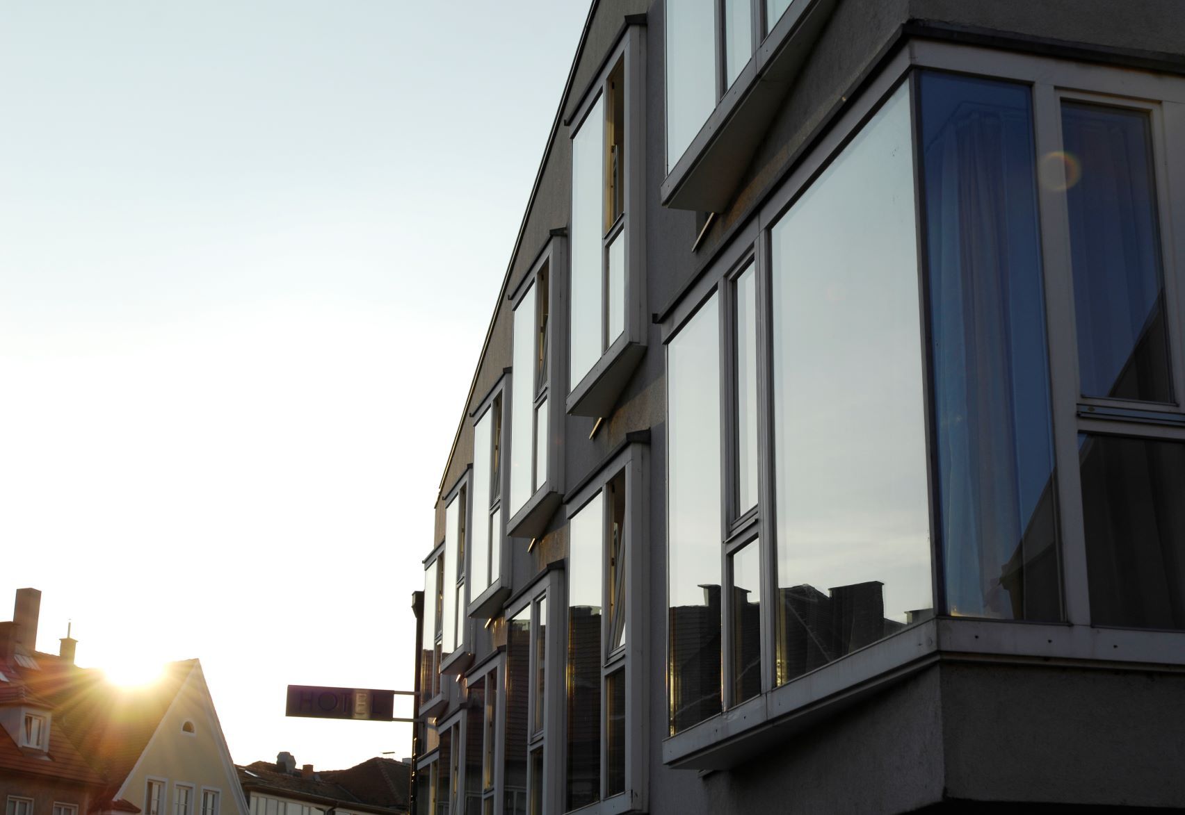 Modern building façade with large windows in the sunset.
