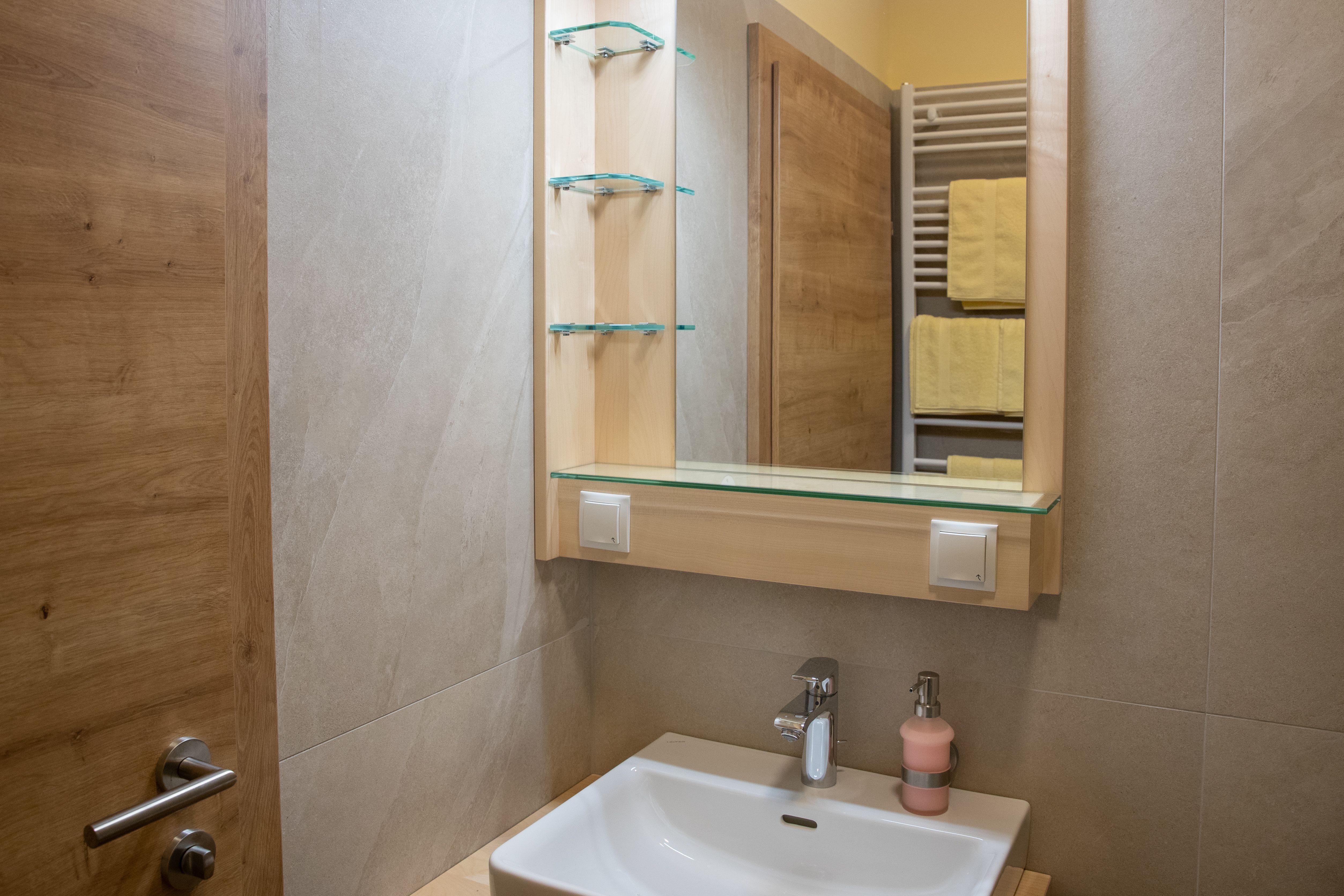 Modern bathroom with washbasin, mirror and towel rail.