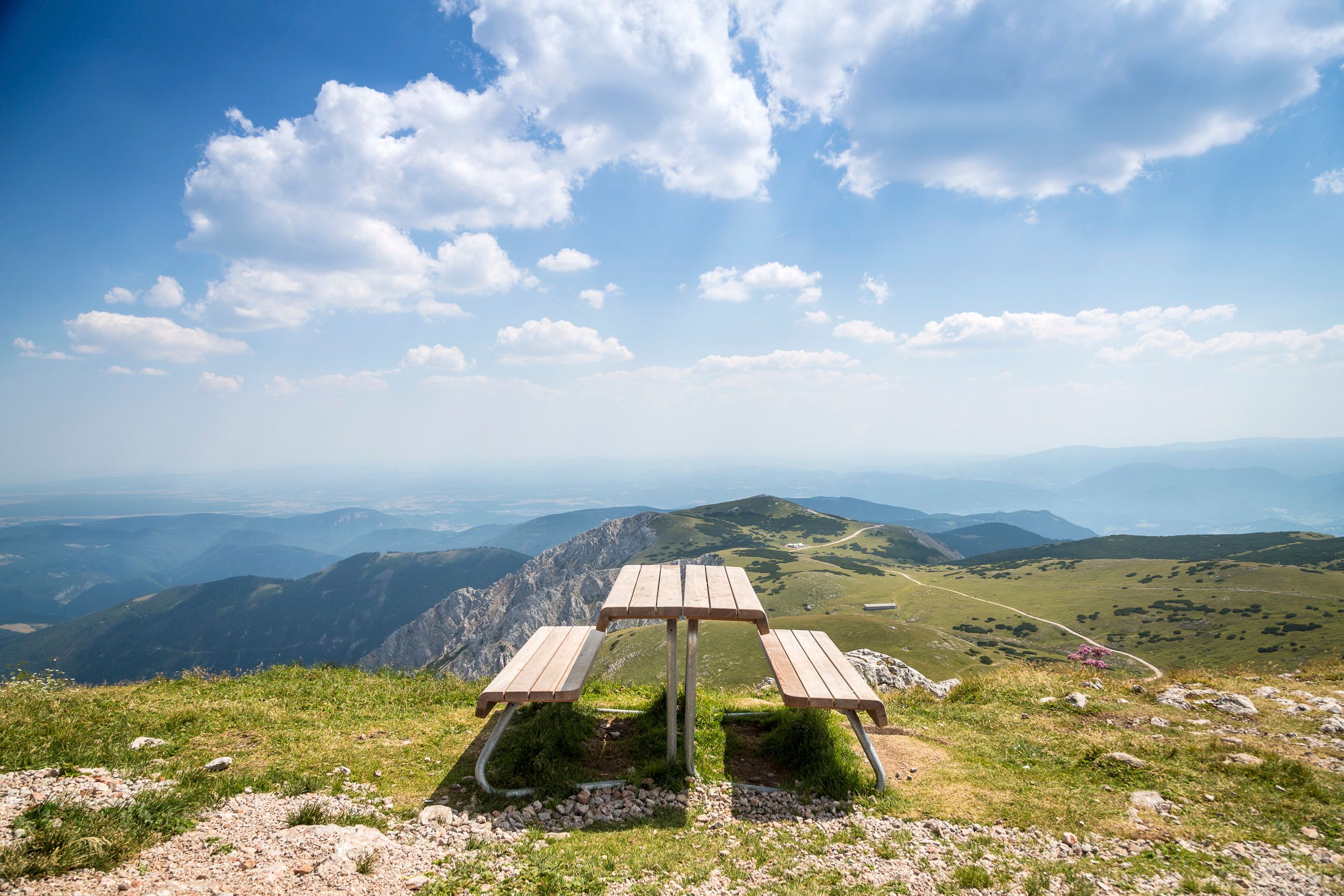 Picnic table on a mountain with a wide view over the landscape.