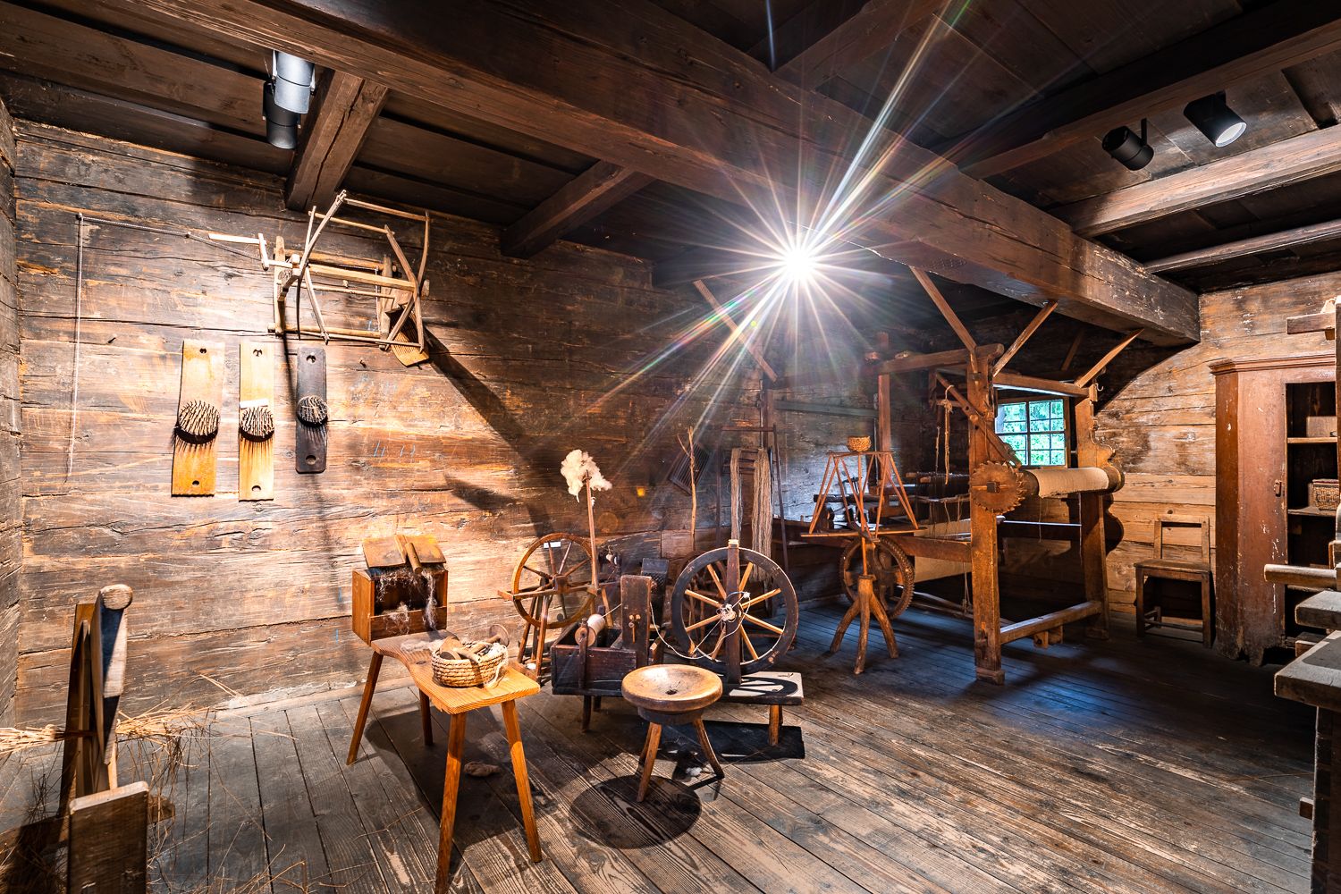 Interior view of an old workshop with wooden tools and spinning wheels in the Krumbach museum village.