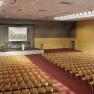 Large conference hall with stage and rows of chairs.