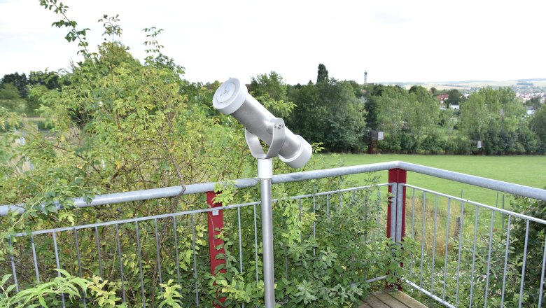 Viewing platform with telescope and view of the green landscape.