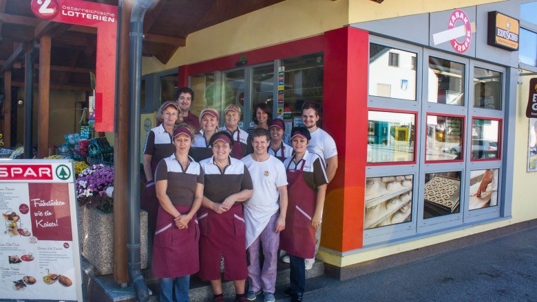 A group of people in work clothes in front of a store.