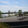 Two benches with a view of a river in sunny weather.