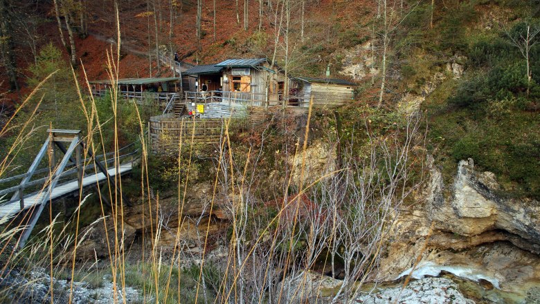 Wooden hut in the &Ouml;tschergr&auml;ben with bridge and autumnal landscape.