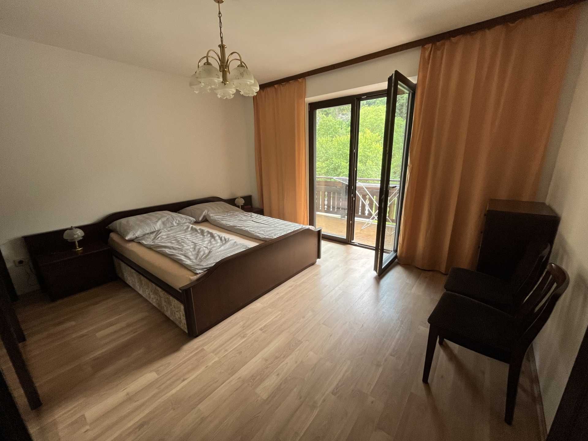 Bedroom with double bed, balcony and curtains.