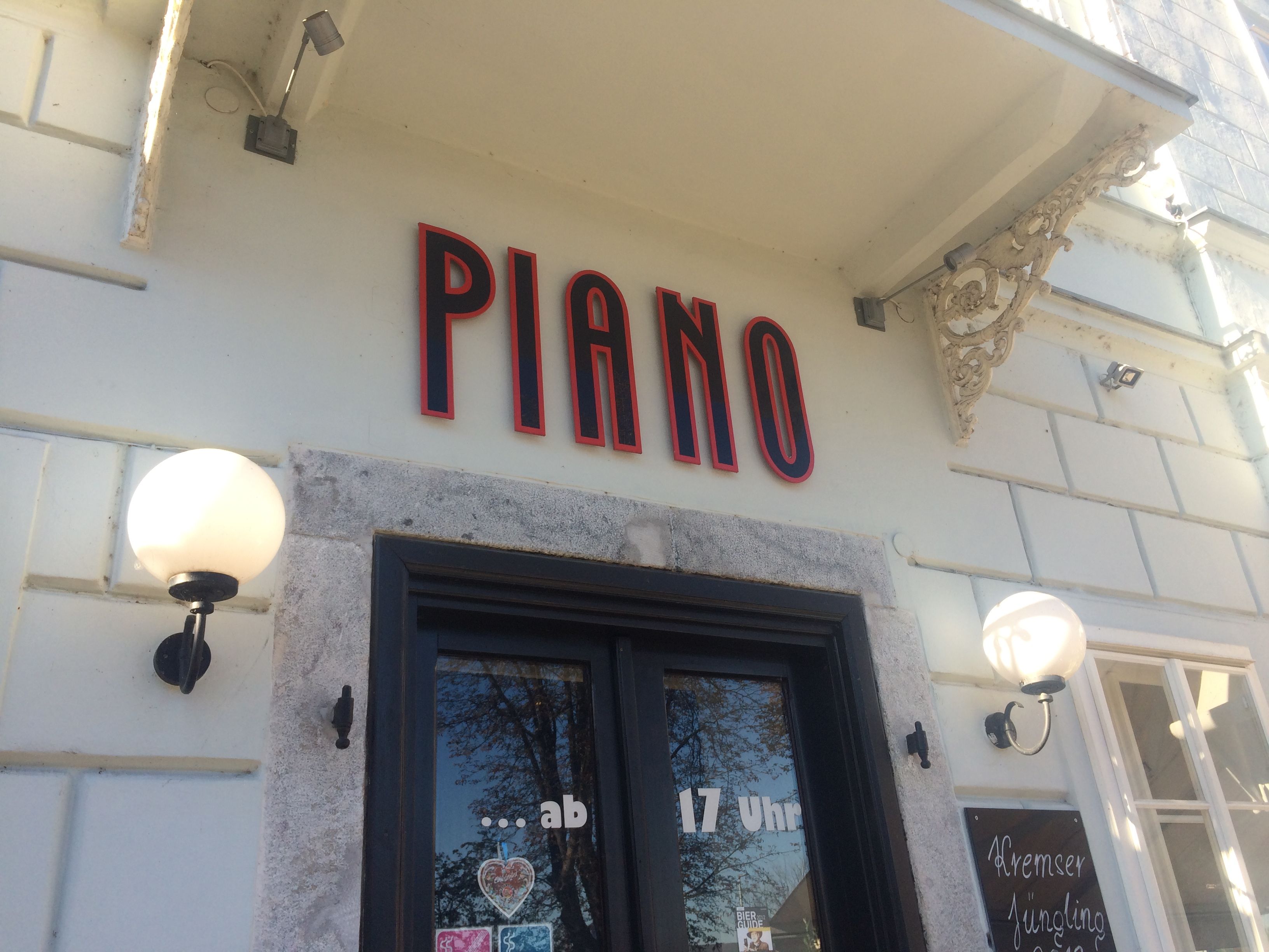 Entrance of a restaurant with the lettering 'Piano' above the door.