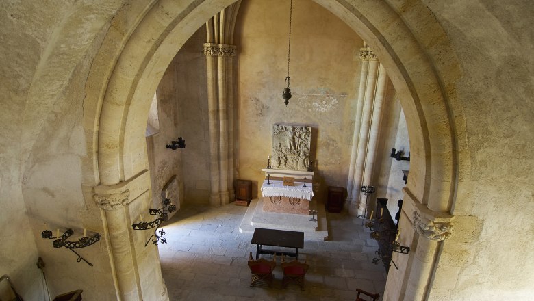 Interior view of a historic chapel with altar and Gothic arches.