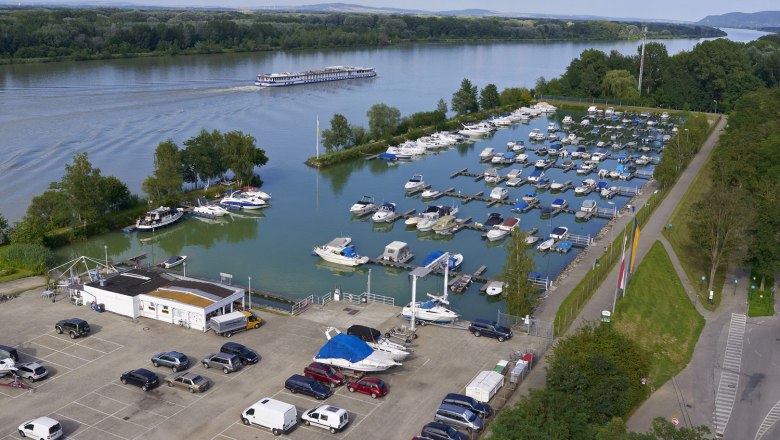 Aerial view of the Tulln marina with many boats and a river in the background.