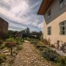 Garden with cobblestone path, bicycle and plants at SONNENTOR Stadt-Lofts.