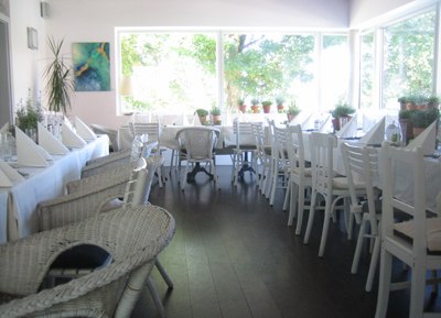 A bright conservatory with white furniture and large windows.