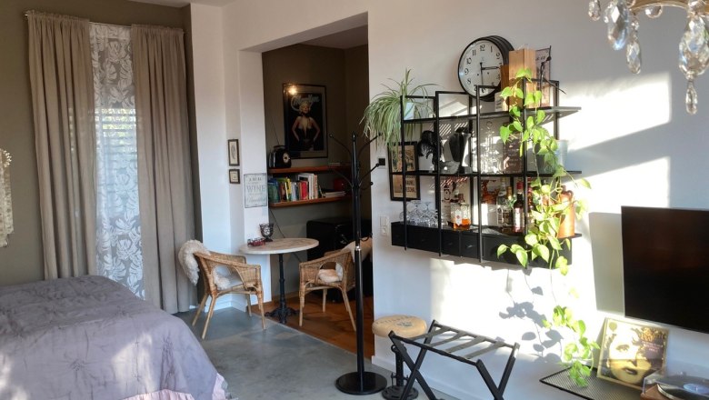 A warm welcome!, © Weitschacher Cozy living room with bed, shelf, plants and wall decoration.