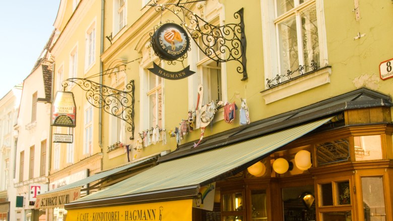 Exterior view of Konditorei Hagmann with yellow canopy and street caf&eacute;.