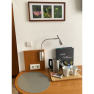 A table with a kettle, two cups, snacks and a welcome booklet. Three nature photos hang on the wall.
