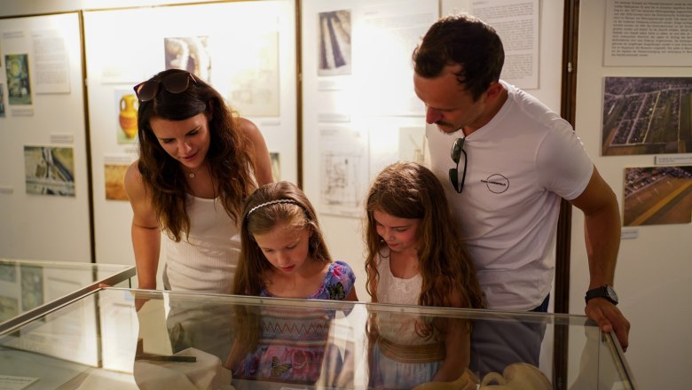 A family looks at exhibits in a museum.