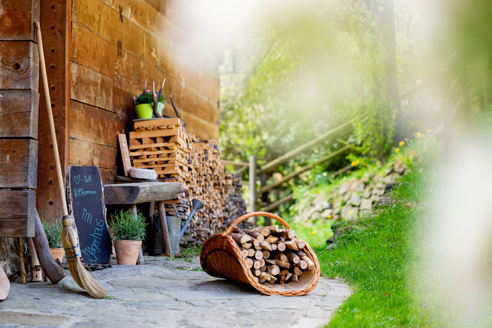 Decorative objects on a stone floor next to a wooden wall and a woodpile.