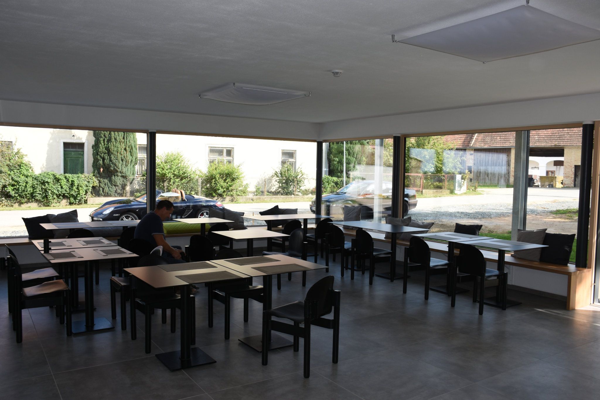 Large breakfast room with fully glazed wall and plenty of seating.