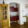 Small kitchen with wooden furniture, red cupboards and coffee machine.