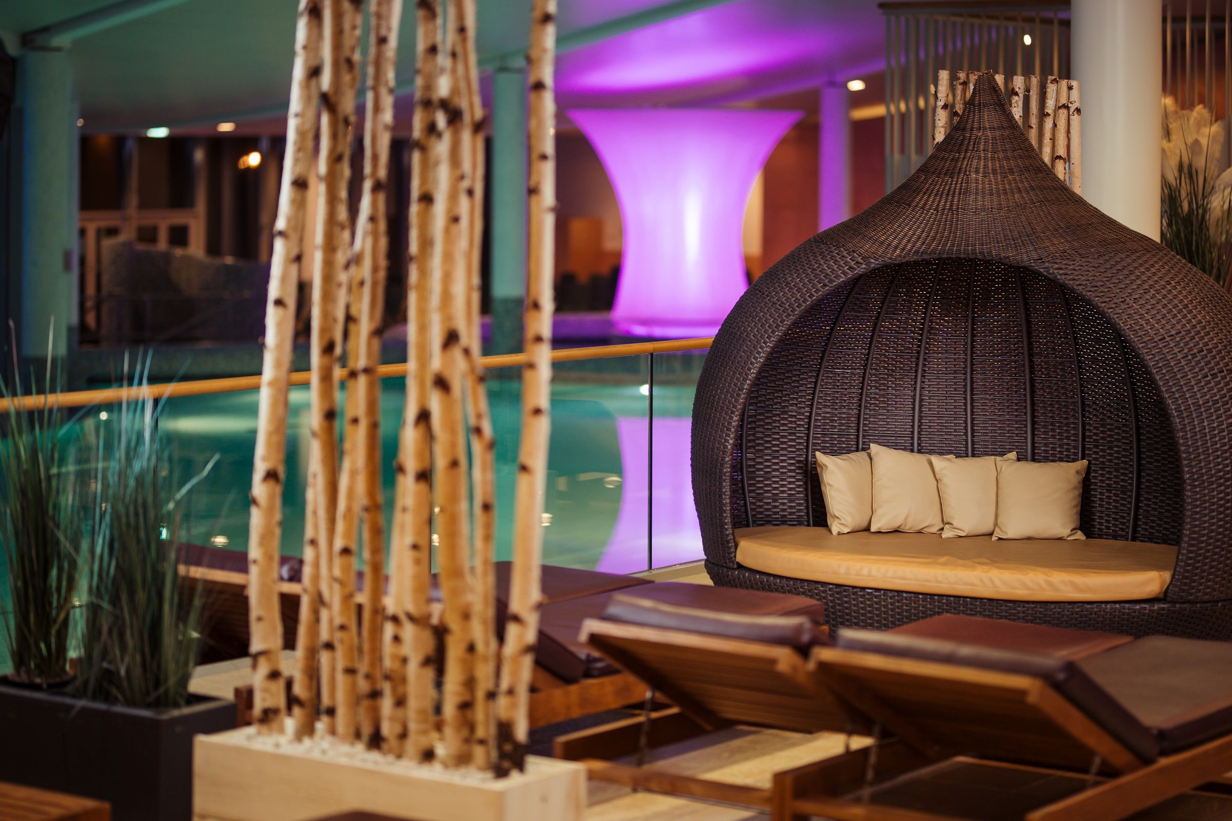 Relaxation area with loungers and wicker chairs in a spa.